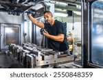 Serious male caucasian engineer inspecting a milling machine in an innovative metal cnc factory