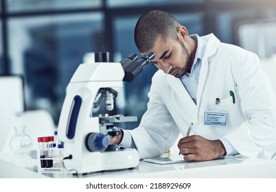 Serious Male Scientist Writing On A Tablet For An Online Phd Research Paper In A Lab. Laboratory Worker Working On Health Data For A Science Journal. Medical Professional Analyzing Test Results