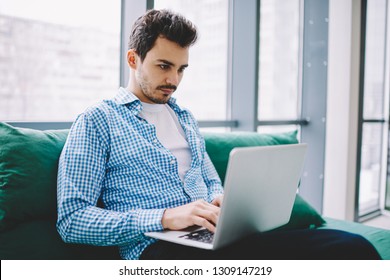 Serious Male Software Developer Working Remotely On Modern Laptop Device Watching Tutorial Webinar Online For Certification Training Connected To 4g Wireless For Browsing Internet On Netbook