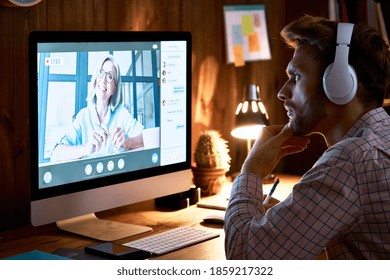 Serious Male Student Wearing Headphones Taking Online Course Training, Watching Webinar, Remote University Class, Virtual Learning With Social Distance Web Teacher, Tutor Or Coach Using Computer.