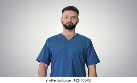 Serious male surgeon with a beard walking on gradient background - Shutterstock ID 1824401405