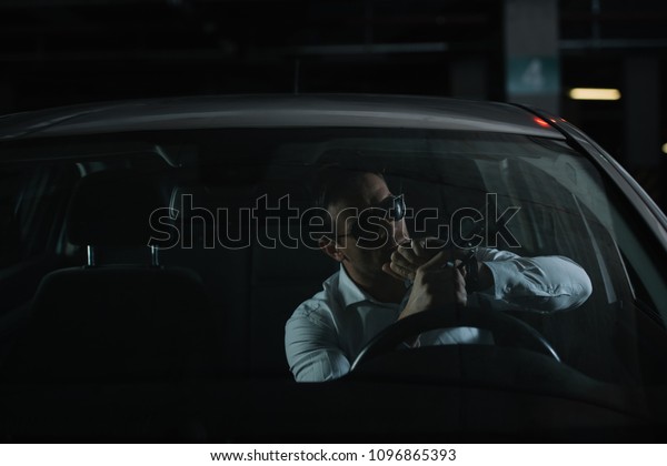 serious male undercover agent in sunglasses charging
gun in car