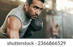 Serious man, dumbbell and weightlifting in workout, exercise or fitness at indoor gym. Active male person, bodybuilder or athlete lifting weight for intense arm training, strength or muscle at club