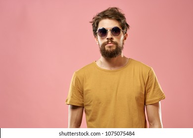 serious man in glasses with a beard on a pink background                               
