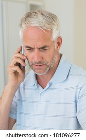 Serious Man On A Phone Call At Home In The Kitchen