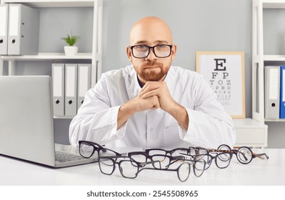 Serious man, ophthalmologist doctor sits in hospital office with eyeglasses on the table. His portrait reflects dedication to healthcare and eye care in the field of ophthalmology. - Powered by Shutterstock