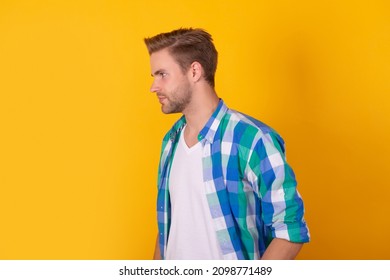 Serious man portrait standing sideway in checked shirt yellow background, profile - Shutterstock ID 2098771489