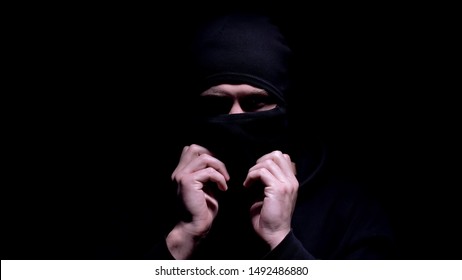 Serious Man Putting On Balaclava, Preparing For Murder Or Robbery, Banditry