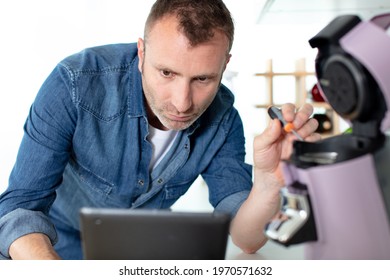 Serious Man Repairing Broken Coffee Machine