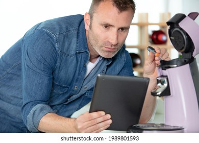 Serious Man Repairing Broken Coffee Machine