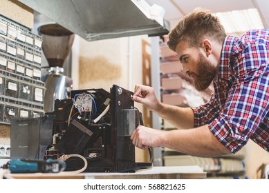 Serious Man Repairing Broken Coffee Machine