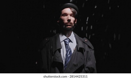 Serious man standing under a dramatic spotlight in the rain