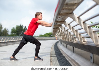 Serious Man Stretching Calf and Leaning on Railing