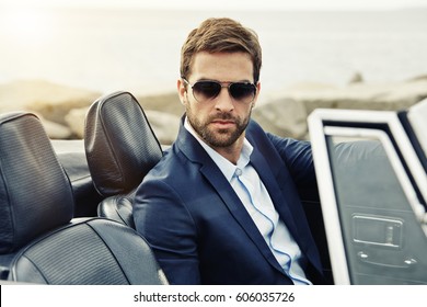 Serious Man Suited In Sports Car, Portrait