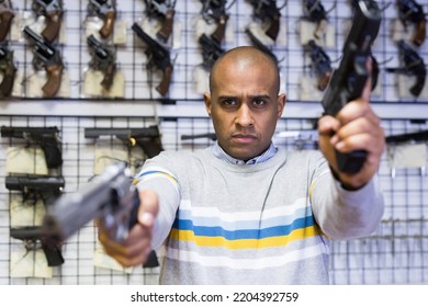 Serious Man Taking Aim With Pistol At Gun Shop