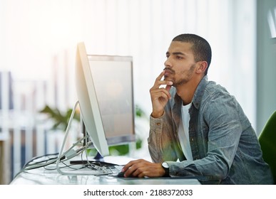 Serious Man Thinking While Working And Reading On A Computer While In A Creative Office. Male Web Designer Using The Internet For Innovation While Trying To Solve A Problem And Finish A Design