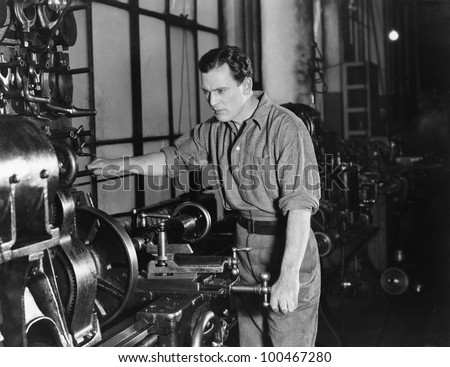 Serious man using large machine