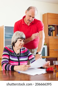 Serious Mature Couple Calculating Family Budget At Home  