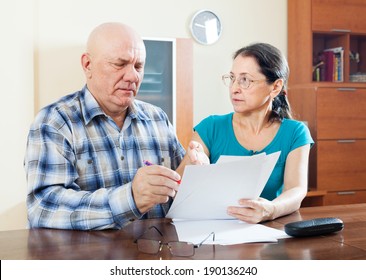 Serious Mature Couple Fills In Questionnaire  At Home