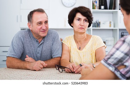 Serious Mature Couple Having Conversation With Adult Daughter At Home