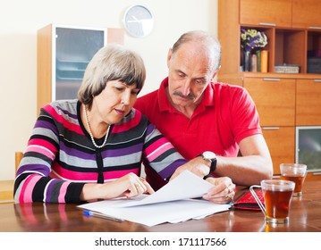 Serious Mature Couple Reading Financial Document Together 