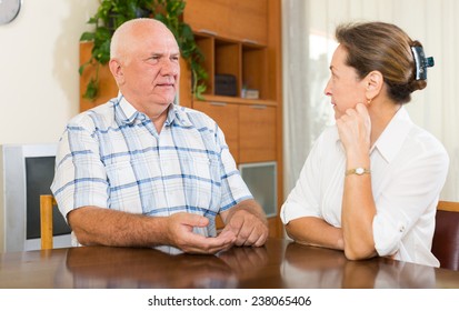 Serious Mature Couple Talking At Home. Focus On Man