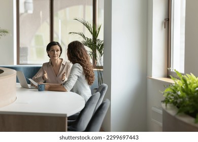 Serious mature female executive manager lead formal meeting with company client in office, make commercial offer, share information, convince customer to buy services met in modern workspace. Business - Shutterstock ID 2299697443