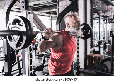 Serious Mature Male Is Having Intense Workout In Gym