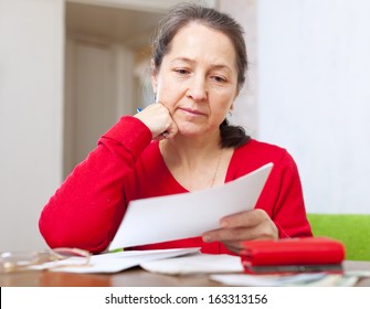 Serious Mature Woman Reads Payment Bills At Home