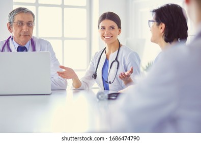 Serious medical team discussing patient's case in a bright office