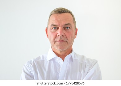 Serious Middle-aged Man With Deadpan Expression Staring Intently At The Camera In A Head And Shoulders Portrait On White