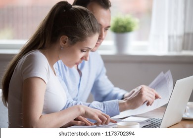 Serious Millennial Couple Read Documents Managing House Utility Bills, Man And Woman Analyze Bank Notice Or Insurance Considering Terms, Husband And Wife Hold Papers Calculating Finances Or Budget