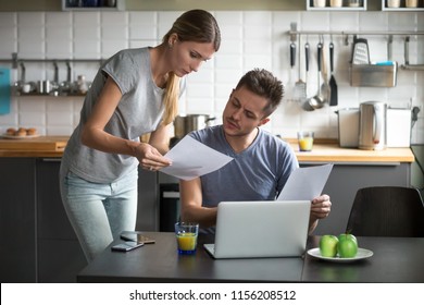 Serious Millennial Couple Worried About High Utility Bills Or Rent Payment Reading Papers In Kitchen, Confused Husband And Wife Discussing Bad News In Bank Loan Document Having Debt Financial Problem