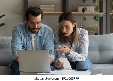 Serious millennial spouses engaged in housekeeping manage family finances discuss budget. Concentrated young couple husband wife sit on sofa at home office talk study receipts calculate loan payments - Powered by Shutterstock