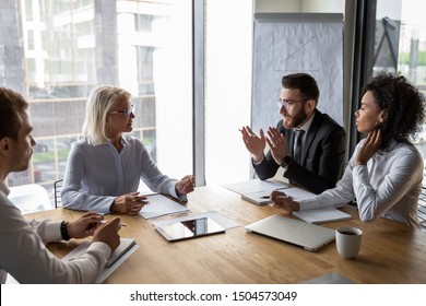 Serious multi-ethnic business entities gathered together for negotiating meeting lead by Arabian and aged businesspeople talk express opinion offer solutions solve current issues, partnership concept - Shutterstock ID 1504573049
