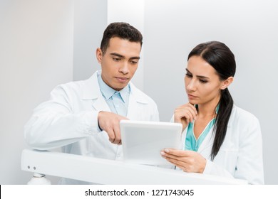 Serious Multiethnic Doctors Looking At Digital Tablet 