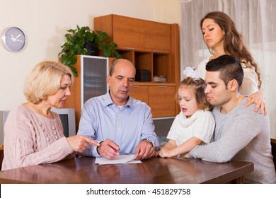 Serious Multigenerational Family Members With Bills And Without Money At The Table  Indoor