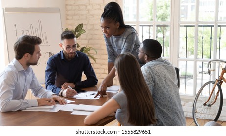 Serious multiracial corporate business team workers take part at group brainstorming discussion of financial report paperwork engaged in teamwork at office, meeting lead by african woman company boss - Shutterstock ID 1555829651