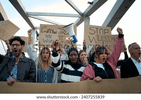 Serious multiracial young group demonstrating against the war and violence in the world. People gathered with written banners with messages for peace and anti-war