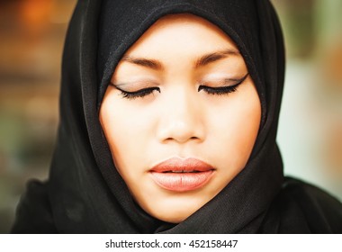 Serious Muslim Indonesian Woman With Closed Eyes