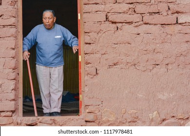 Serious Native American Old Man With Walking Stick Leaving His House In The Countryside. 