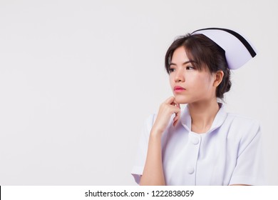 Serious Nurse Thinking And Looking Up. Portrait Of Stressed And Serious Asian Woman Nurse Planning, Finding Idea, Thinking On Studio White Isolated Background