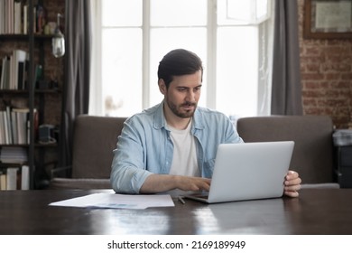 Serious Office Employee Sit At Desk Working On Laptop, Prepare Report, Makes On-line Presentation Looks Focused At Homeoffice Workplace. Workflow, Professional Business Application, Tech Usage Concept