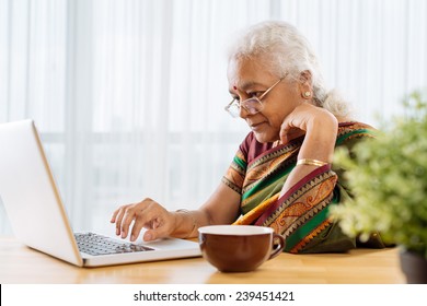 Serious Old Indian Lady Working On Laptop