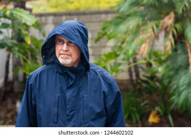 Serious Older Man Standing In The Rain In Yard Looking Away 