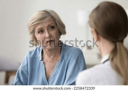 Serious older patient woman visiting doctor, getting geriatric health problems after medical checkup, listening to practitioner explaining diagnosis, giving treatment, therapy recommendation