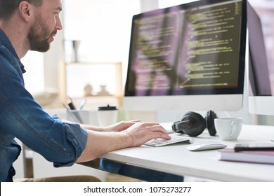 Serious Pensive Experienced Male Programmer Typing Code On Computer While Working On New Software Application In Modern Comfortable Office