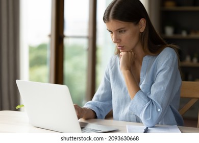 Serious Pensive Female Worker Thinking Over Work Task At Laptop, Reading Message, Email In Deep Thought, Using Online Application On Compute. Focused Student Girl Watching Learning Webinar