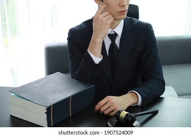 Serious Pensive Lawyer Working At Desk In Office
