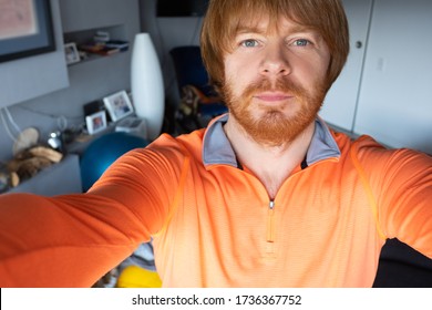 Serious Pensive Red Haired Man Staying At Home During Lockdown, Taking Selfie. Closeup, Self Portrait, Front View. Person In Home Interior Concept